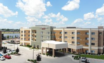 a large hotel with a green and tan exterior is shown in the image at Courtyard Bay City