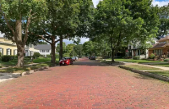 Historic house on tree lined red brick street of historic homes.