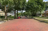 Historic house on tree lined red brick street of historic homes.