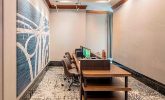 a modern office space with two desks , a chair , and a large blue and white mural on the wall at Courtyard by Marriott Boston Brookline