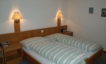a hotel room with two beds , one on the left and one on the right side of the room at Hotel Residence