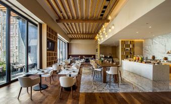 a restaurant with wooden tables and chairs , a bar , and a large window in the background at Hyatt Regency Andares Guadalajara