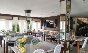a large dining room with multiple tables and chairs arranged for a group of people to enjoy a meal together at Phusuay Park View Hotel