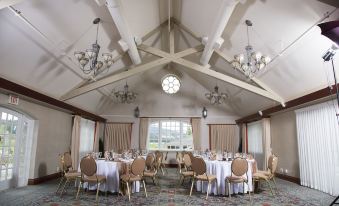 a large dining room with multiple round tables and chairs arranged for a formal event at St. Eugene Golf Resort & Casino