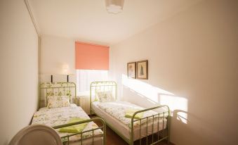 a room with two beds , one on the left and one on the right side of the room at Garden Apartment