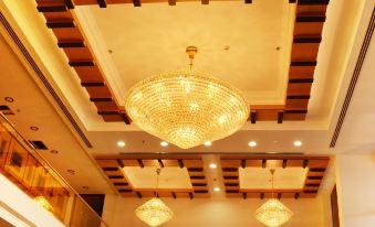 a large chandelier hangs from the ceiling of a room with three hanging lights and wooden panels at Nooh Tower