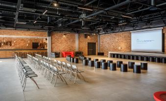 a large , empty room with a brick wall and a long dining table in the center at Lanterna Premium Camping Resort by Valamar