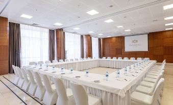a conference room set up for a meeting , with tables and chairs arranged in a semicircle at Shahdag Hotel & Spa