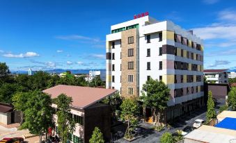 a large hotel building situated in a city , surrounded by trees and other buildings , with a clear blue sky above at Soho Boutique Hotel