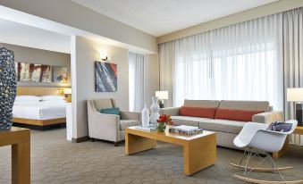 a well - furnished hotel room with a couch , chairs , and a coffee table in the living area at Renaissance Chicago Glenview Suites Hotel