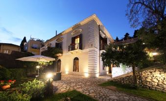 a large , white house with a balcony and stone pathway in front of it at night at Hotel Continental