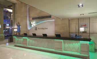 The lobby features a spacious counter with lights on both sides, as well as an illuminated wall at Holiday Inn Macau