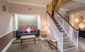 a living room with a couch , coffee table , and stairs leading to the second floor at The Knaresborough Inn - the Inn Collection Group