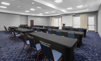 a large conference room with multiple rows of chairs arranged in a semicircle , and a podium at the front of the room at Courtyard Tampa Oldsmar