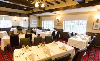 a large dining room with multiple tables and chairs arranged for a group of people to enjoy a meal together at Ellerby Country Inn