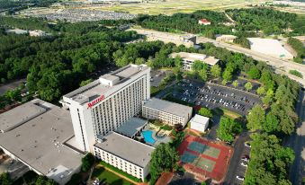 aerial view of a large hotel surrounded by trees , with a swimming pool in the foreground at Atlanta Airport Marriott