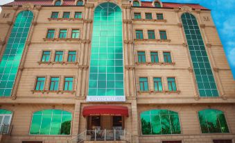 a large , modern building with green windows and a red awning , situated in an urban environment at Continental Hotel