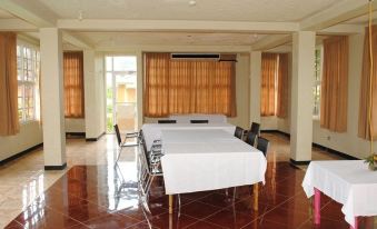 a large room with a long table set for a meeting , surrounded by chairs and windows at Oasis Resort