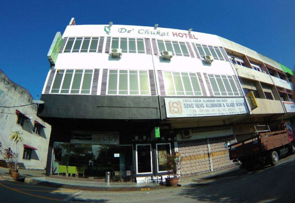 "a large building with a sign that reads "" o ' caras hotel "" is shown on a street corner" at De' Chukai Hotel