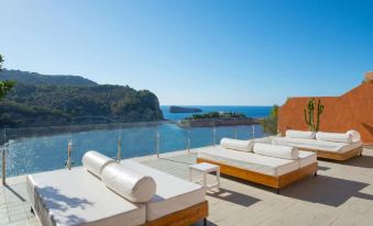 a rooftop patio overlooking a body of water , with several lounge chairs arranged in a row at Hotel Galeón