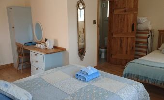 a room with two beds , one on the left side and another on the right side at Church Farm Accommodation