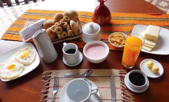 a dining table is set with a variety of breakfast foods , including eggs , toast , and coffee at Hotel Casablanca