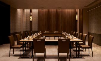 A spacious meeting room with long tables and brown upholstered chairs is available for private meetings or other events at Dusit Thani Kyoto