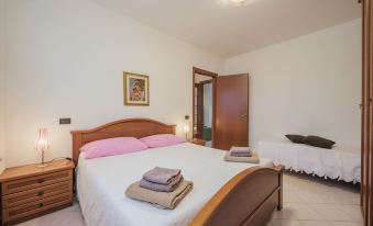 a well - decorated bedroom with two beds , white bedding , and towels , along with a nightstand and window at Anna