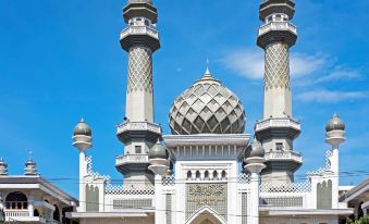 a large white mosque with two tall minarets and a dome , surrounded by a blue sky at Adel Guest House