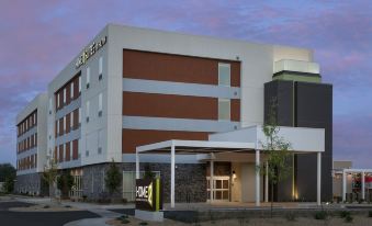 "a large building with a sign that says "" hotel "" is shown at dusk , with a parking lot in front" at Home2 Suites by Hilton Marysville