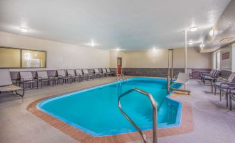 an indoor swimming pool surrounded by chairs and a hot tub , providing a relaxing atmosphere at La Quinta Inn & Suites by Wyndham Fairborn Wright-Patterson
