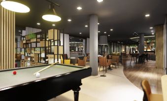 a large room with a pool table in the center , surrounded by chairs and tables at Mercure HAN Sur Lesse