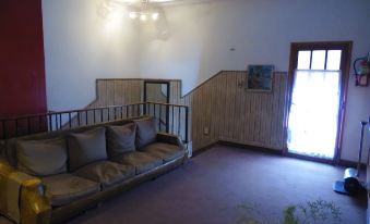 a living room with a couch , a chair , and a tv . the room is well - lit and appears to be empty at Hotel San Francisco