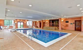 an indoor swimming pool with a blue tiled floor and white steps leading up to it at Homewood Suites by Hilton Stratford