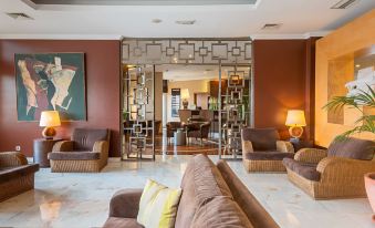 a modern living room with a couch , chairs , and a dining table in the background at Amazonia Jamor Hotel