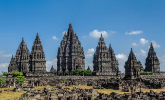 a large , ancient temple complex with multiple pagodas and ruins , set against a blue sky at RedDoorz Near Candi Ratu Boko