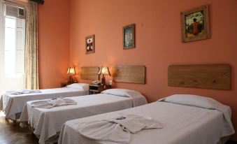 a hotel room with three beds , one on the left , one in the middle , and one on the right at Plaza Hotel