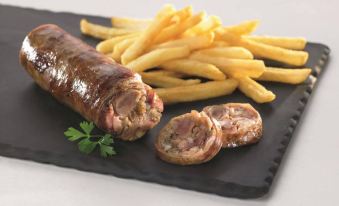 a black plate with a variety of food items , including french fries , sausages , and onions at Kyriad Lille Est - Hem
