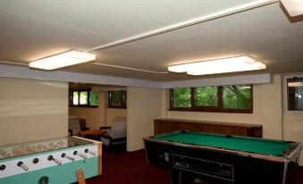 a room with a pool table and a foosball table , as well as a dining table and chairs at Relax Inn