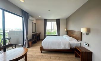 a modern hotel room with wooden flooring , large windows offering city views , and a comfortable bed at The Mangrove Hotel