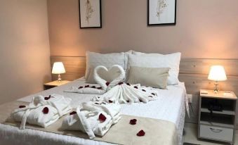a cozy bedroom with a bed adorned with rose petals , creating a romantic atmosphere at Hotel San Remo