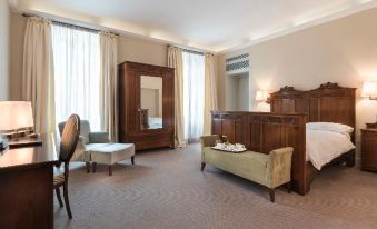a luxurious hotel room with a large wooden bed , a bench , and a flat - screen tv at Grand Hotel Della Posta