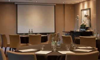 a conference room set up for a meeting , with chairs arranged in a circle and a projector on the wall at Dakota Edinburgh