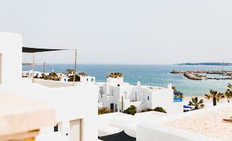 a picturesque view of a white building overlooking the ocean , with a rooftop terrace in the foreground at Paliomylos Spa Hotel