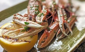 a platter of cooked crab legs on a dining table , accompanied by a lemon and a knife at Isle of Mull Hotel and Spa