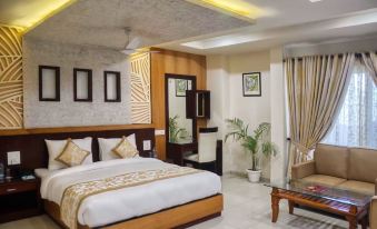 a large bed with white linens is in a room with wooden furniture and potted plants at Emporio Hotel