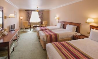 a hotel room with three beds , two of which are twin beds and one is a double bed at Londonderry Arms Hotel