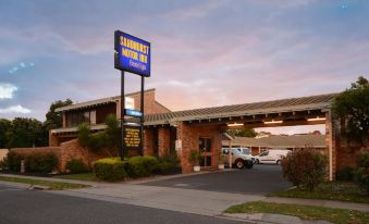 "a parking lot with cars parked , a building with a sign that says "" sarsaparak motor inn "", and a car in front of" at Sandhurst Motor Inn Bendigo