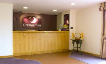 "a reception desk with a wooden finish and a sign that reads "" premier inn "" in the background" at Premier Inn Pontefract North