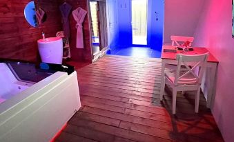a modern , minimalist room with wooden flooring and a white bathtub , decorated with pink and blue lighting at Lovely